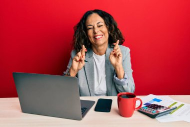 Ofiste çalışan orta yaşlı güzel bir kadın bir fincan kahve içip umut ve gözlerin kapalı gülümseyerek el sallıyor. Şans ve batıl inançlar. 