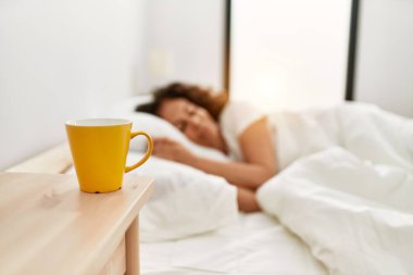 Orta yaşlı İspanyol kadın yatak odasında yatakta uyuyor.