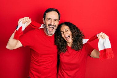 Orta yaşlı bir çift İspanyol kadın ve atkı takan bir adam futbol takımı holiganları tezahürat oyunu sırıtıyor ve kahkahalarla gülüyorlar.. 