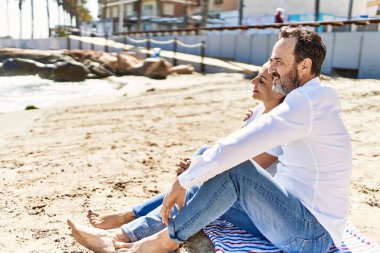 Orta yaşlı İspanyol çift plajda havluda otururken rahatladı..