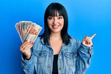 Genç İspanyol kadın elinde Mısır banknotları tutarken mutlu bir şekilde gülümsüyor. 