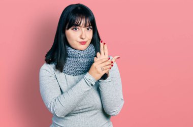 Genç İspanyol asıllı, uzun boylu, eşarp takan, el hareketleriyle sembolik silah tutan, cinayet silahlarıyla oynayan, kızgın yüzlü bir kadın. 