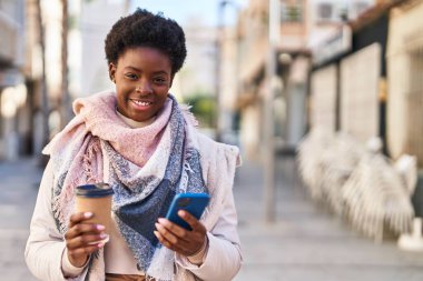 Sokakta kahve içen Afro-Amerikan kadın.