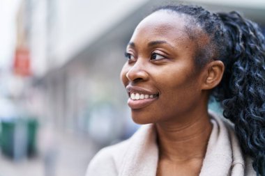 Sokakta kendine güvenen Afrikalı Amerikalı kadın gülümsüyor