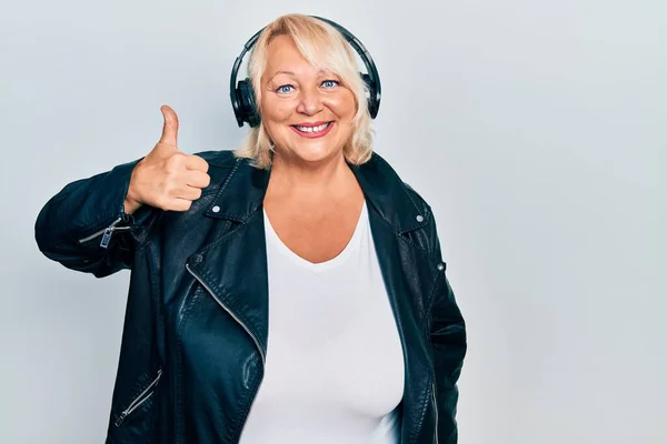 Middelaldrende Blond Kvinne Som Hører Musikk Med Hodetelefoner Som Smiler – stockfoto