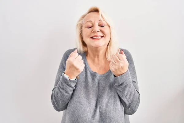 中年的高加索女人站在白种人的背景上 兴奋地期待着成功 举起双臂 闭上双眼 微笑着庆祝胜利 获奖者概念 — 图库照片