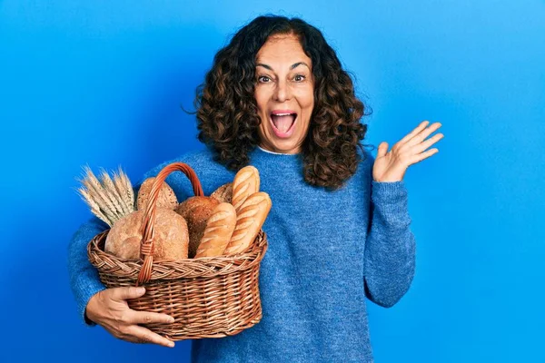 Middle Age Hispanic Woman Holding Wicker Basket Bread Celebrating Victory — 스톡 사진