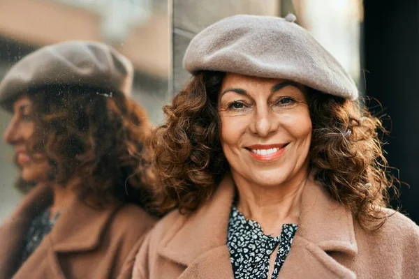 Orta yaşlı İspanyol kadın gülümseyerek şehirde mutlu mesut dikiliyor..