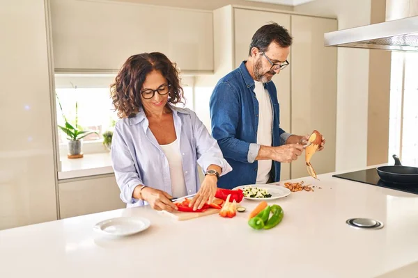 Orta yaşlı İspanyol çift mutfakta kendine güvenen yemekler pişiriyor.