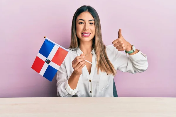 Young Hispanic Woman Holding Dominican Republic Flag Sitting Table Smiling — Stock Fotó