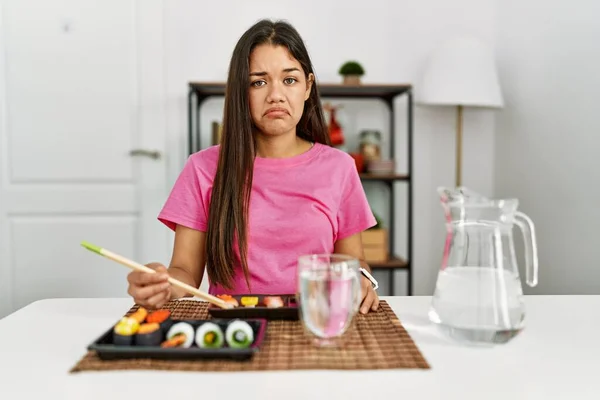 Young Brunette Woman Eating Sushi Using Chopsticks Depressed Worry Distress — Photo