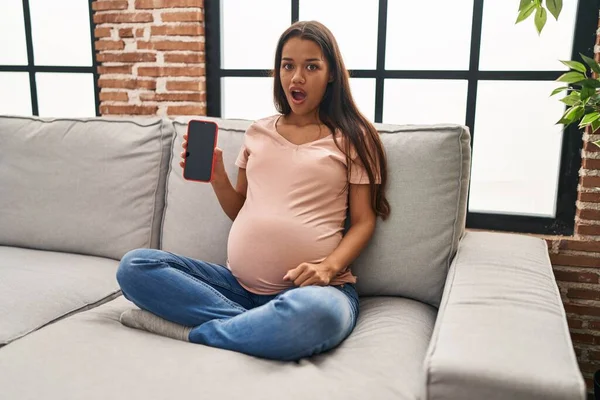 Young Pregnant Woman Holding Smartphone Showing Screen Scared Amazed Open — 스톡 사진