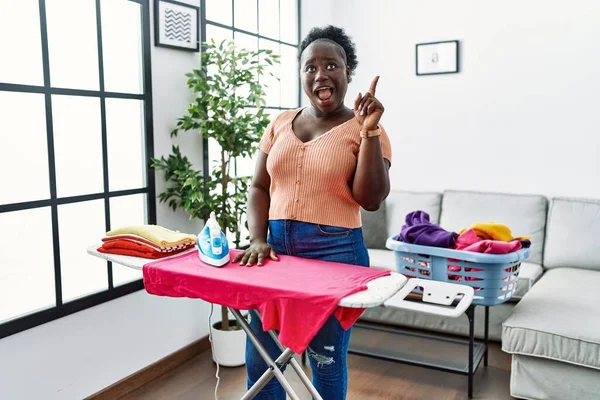 Young African Woman Ironing Clothes Home Pointing Finger Successful Idea — Photo