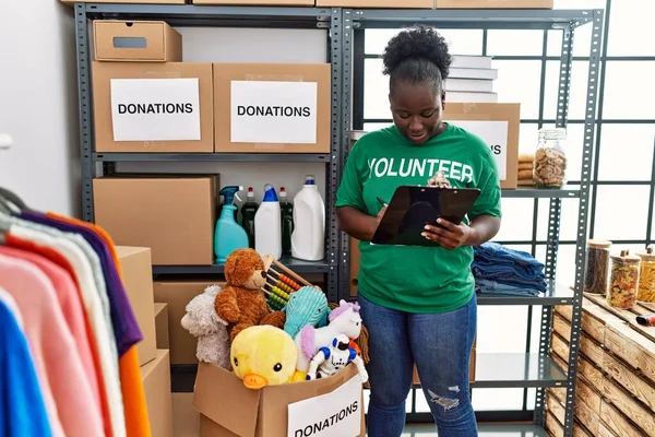 Mujer Afroamericana Joven Con Uniforme Voluntario Escrito Portapapeles Centro Caridad — Foto de Stock