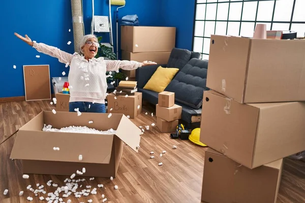 Middle Age Woman Smiling Confident Throwing Foam Package New Home — 스톡 사진