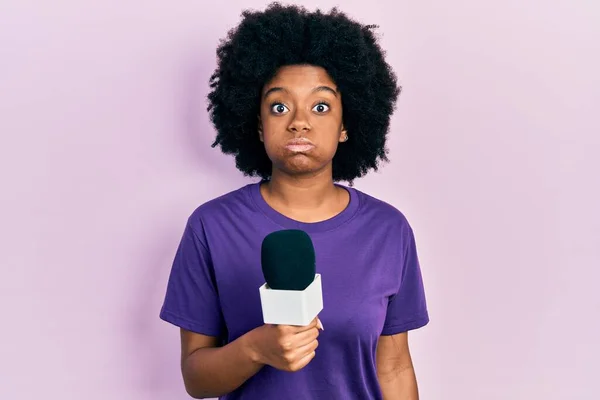 Young African American Woman Holding Reporter Microphone Puffing Cheeks Funny —  Fotos de Stock