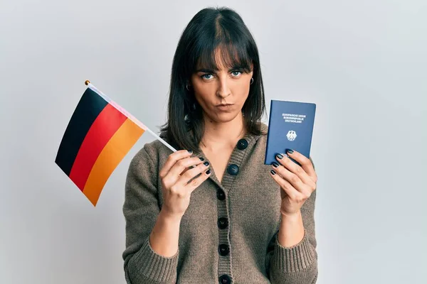 Młoda Latynoska Kobieta Niemiecką Flagą Paszportem Sceptyczna Nerwowa Marszcząca Brwi — Zdjęcie stockowe