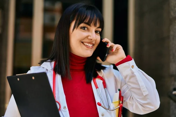 Mujer Morena Joven Vistiendo Uniforme Médico Hablando Por Teléfono Entrada —  Fotos de Stock