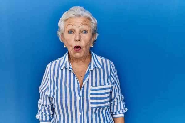 头发灰白的老妇人站在蓝色的背景上 惊讶的表情 恐惧和兴奋的脸 — 图库照片