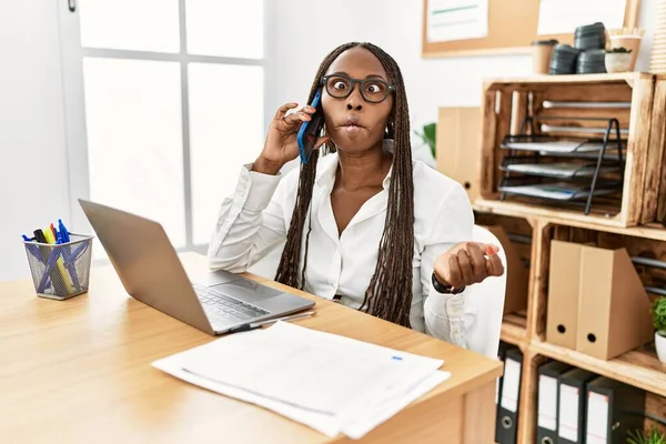 Μαύρη Γυναίκα Κοτσίδες Που Δουλεύει Στο Γραφείο Μιλώντας Στο Τηλέφωνο — Φωτογραφία Αρχείου