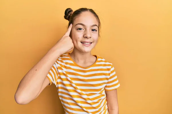 Beautiful Brunette Little Girl Wearing Casual Striped Shirt Smiling Pointing — 스톡 사진