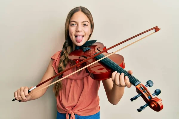 Красивая Брюнетка Маленькая Девочка Играющая Скрипке Торчащей Языком Довольная Смешным — стоковое фото