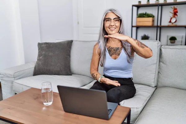 Medelålders Gråhårig Kvinna Använder Laptop Hemma Gester Med Händerna Visar — Stockfoto