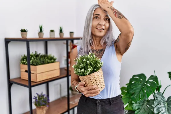 Middelbare Leeftijd Grijsharige Vrouw Met Groene Pot Plant Thuis Verrast — Stockfoto