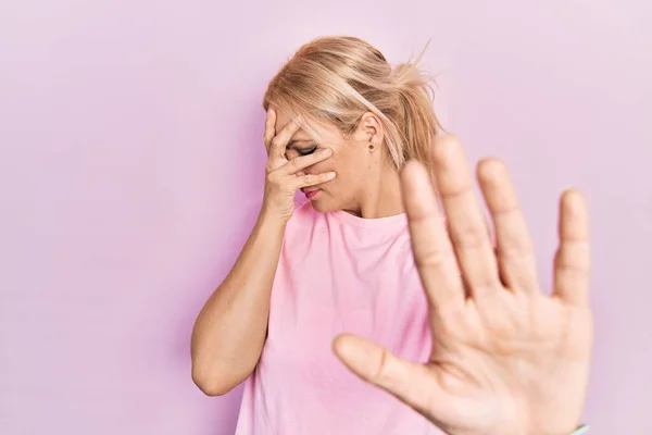 Young Blonde Woman Wearing Casual Pink Shirt Covering Eyes Hands — Foto de Stock