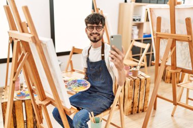 Genç İspanyol ressam resim stüdyosundaki akıllı telefon çiziminden özçekim yapıyor..