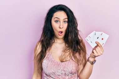 Genç İspanyol kadın elinde poker kartları tutuyor. Korkmuş ve ağzı açık kalmış, şaşırmış ve şaşırmış. 