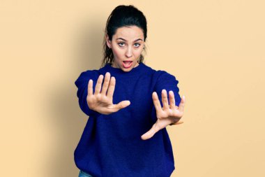 Gündelik kıyafetler giyen genç İspanyol kadın avuç içi hareketlerini durduruyor, kızgın ve hayal kırıklığı dolu bir ifade takınıyor. 