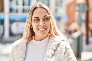 Sokakta kendinden emin gülümseyen genç bir kadın