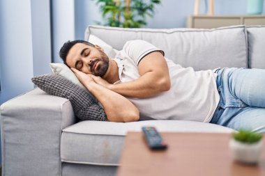 Genç İspanyol adam evdeki kanepede uyuyor.