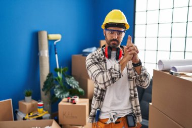 Sakallı, evde çalışan, el hareketleriyle sembolik silah tutan, cinayet silahlarıyla oynayan, sinirli yüzlü, İspanyol asıllı genç bir adam. 