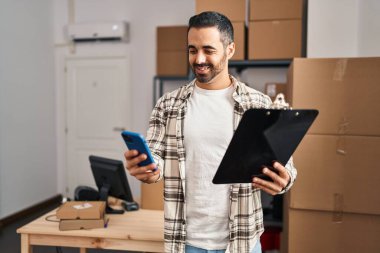 Genç bir İspanyol iş adamı ofisteki akıllı telefon okuma belgesini kullanıyor.