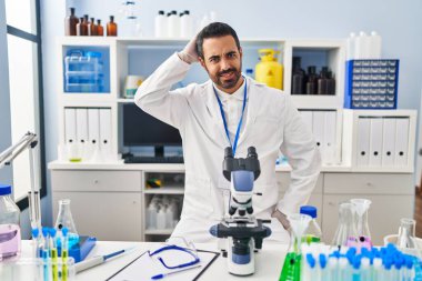 Sakallı, labaratuvarda çalışan Latin asıllı genç adam soru sorup duruyor. Şüpheyle kararsız, kafa kafaya düşünerek. Düşünceli kavram. 