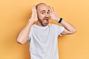 Gündelik beyaz tişört giyen, neşeli gülümseyen genç kel bir adam ellerini göstererek bir yuhalamaya bakıyor. Şaşırdım ve çıktım. 