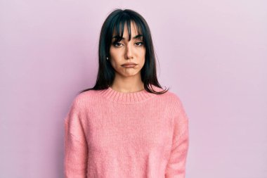 Kâküllü genç esmer kadın günlük kışlık süveter giyiyor. Depresyonda ve sıkıntıdan endişe ediyor. Kızgın ve korkmuş. hüzünlü ifade. 