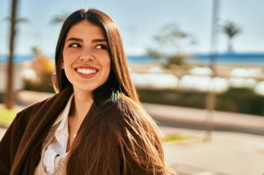 Genç İspanyol kadın gülümseyerek şehirde mutlu mesut dikiliyor..