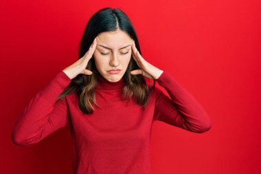 Young brunette woman wearing turtleneck sweater with hand on head, headache because stress. suffering migraine. 