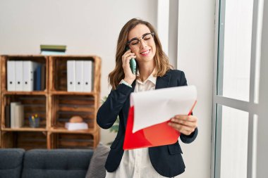 Klinikte psikoloji dersi alan genç bir kadın akıllı telefondan konuşuyor.