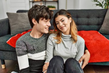 Genç, beyaz bir çift, mutlu bir şekilde gülümsüyor ve kucaklaşıyorlar..