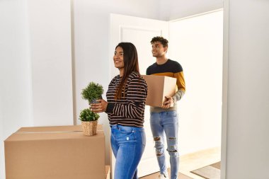 Genç Latin çift gülümsüyor. Mutlu mesut eve giriyorlar..