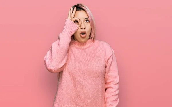 ピンクの髪のカジュアルな冬のセーターを着てヒスパニック系の女性は驚きの顔でショックを受けたOkジェスチャーを行うと 目の指を見て 信じられない表現 — ストック写真