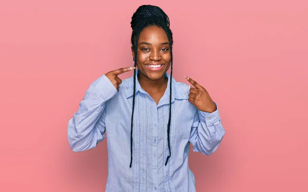 若いアフリカ系アメリカ人の女性は 陽気な笑顔を見せ 指の歯と口で指してカジュアルな服を着ていた 歯の健康の概念 — ストック写真