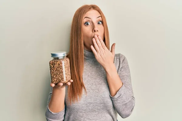 Young Irish Woman Holding Bowl Lentils Covering Mouth Hand Shocked — стоковое фото