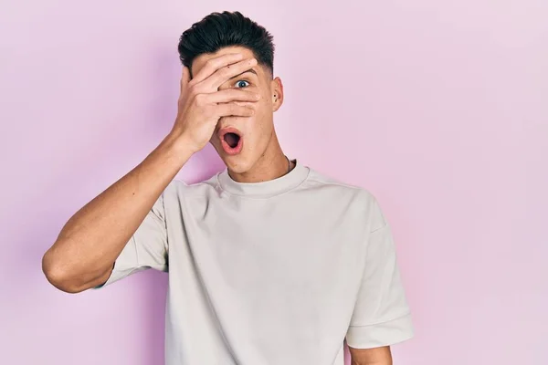 Joven Hombre Hispano Vistiendo Casual Camiseta Blanca Asomándose Shock Cubriendo —  Fotos de Stock