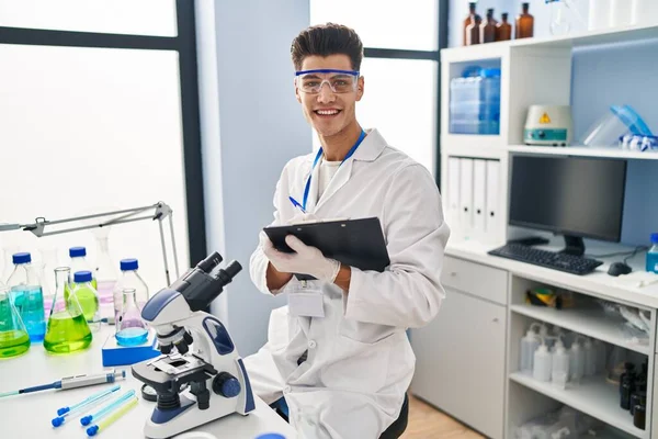 Jovem Hispânico Vestindo Uniforme Cientista Escrevendo Área Transferência Laboratório — Fotografia de Stock