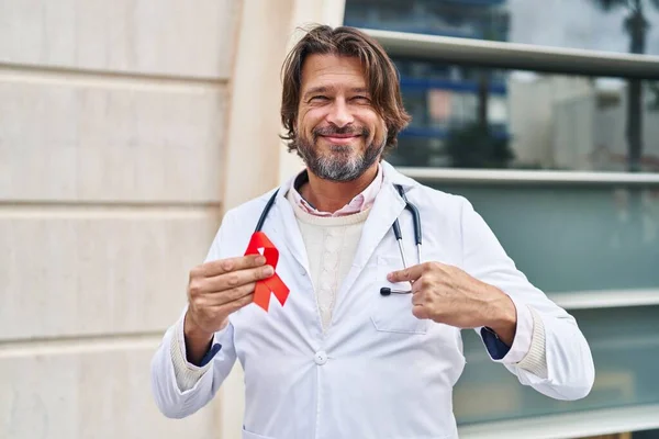 Guapo Médico Mediana Edad Hombre Sosteniendo Apoyo Cinta Roja Señalando — Foto de Stock